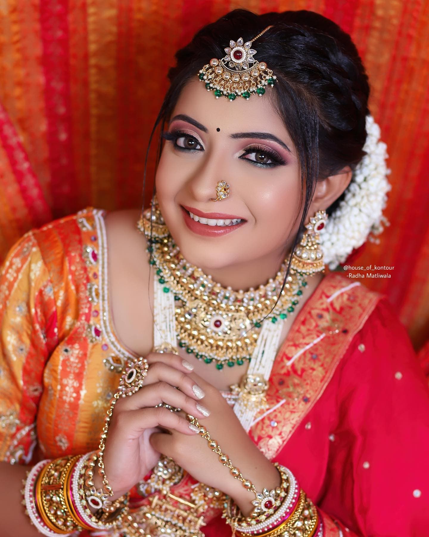 Bride in red and gold with a polished traditional makeup look